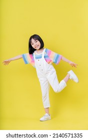 Full Length Image Of Asian Child Posing On Yellow Background