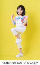 Full length image of Asian child posing on yellow background - Shutterstock ID 2140571339
