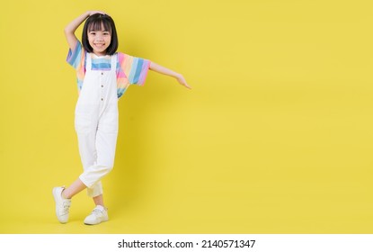 Full Length Image Of Asian Child Posing On Yellow Background