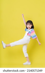 Full length image of Asian child posing on yellow background - Shutterstock ID 2140571349