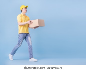 Full length image of Asian delivery man on blue background