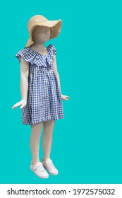 Full length image of a child display mannequin wearing beautiful clothes isolated on a green background.