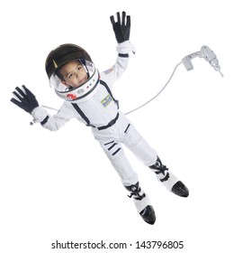 Full length image of an elementary astronaut in full gear floating in space.  He has an attached dress floating nearby.  On a white background.