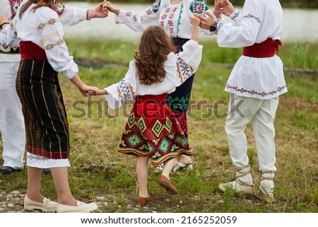 Full length image of a family with kids in traditional romanian clothes, dancing outside. Foto stock © 