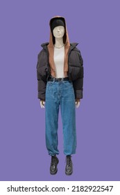 Full length image of a female display mannequin wearing warm fashionable clothes isolated on a purple background