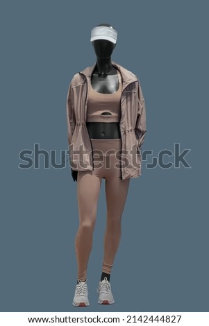 Full length image of a female display mannequin wearing sportswear isolated on a blue background