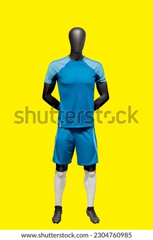 Full length image of a male display mannequin wearing sportswear isolated on yellow background