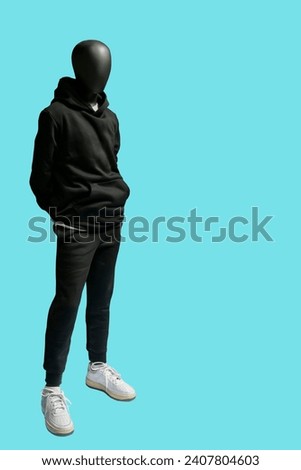 Full length image of a male display mannequin wearing black sports suit isolated on blue background