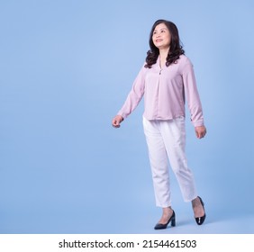 Full Length Image Of Middle Aged Asian Woman On Blue Background