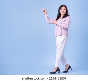 Full Length Image Of Middle Aged Asian Woman On Blue Background