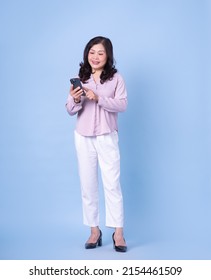 Full Length Image Of Middle Aged Asian Woman On Blue Background