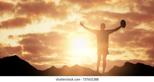 Full length image of rugby player holding ball against low angle view of sky  - Powered by Shutterstock