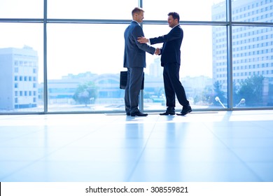 Full Length Image Of Two Successful Business Men Shaking Hands With Each Other