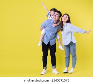 Full length image of young Asian family on background