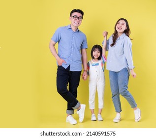 Full length image of young Asian family on background