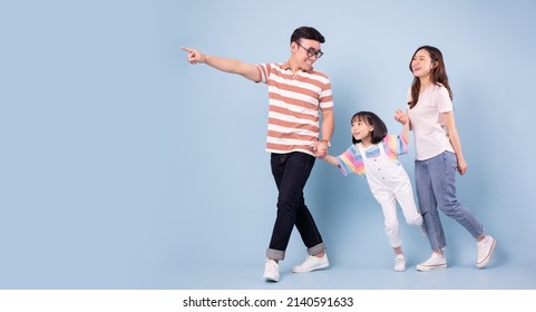 Full Length Image Of Young Asian Family On Background