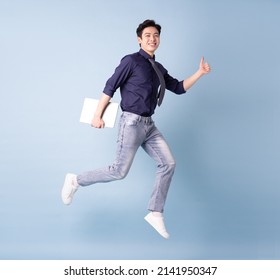 Full length image of young Asian businessman on blue background - Shutterstock ID 2141950347