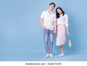 Full Length Image Of Young Asian Couple On Blue Background