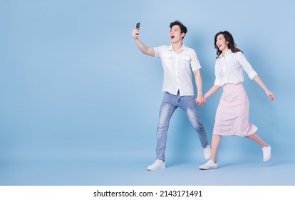 Full Length Image Of Young Asian Couple On Blue Background