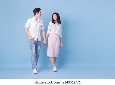 Full Length Image Of Young Asian Couple On Blue Background