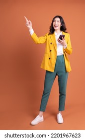 Full length image of young Asian woman using smartphone on background - Shutterstock ID 2201967623