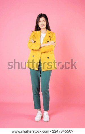 Full length image of young Asian business woman standing on background