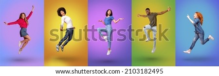 Full length of joyful millennial international people jumping together, smiling at camera over bright neon studio backgrounds, panorama. Young guys and ladies celebrating success and having fun