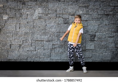 Full Length Of A Kid Having Fun While Doing Floss Dance Against The Wall. Copy Space. 