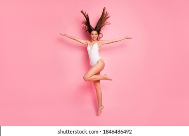 Full length of lovely millennial raise hands legs dressed swim wear standing isolated over pink background