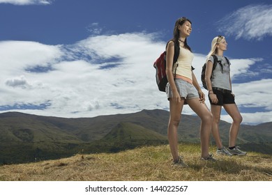 Full length low angle view of two young women hiking in hills
