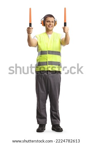Full length pоrtrait of a male aircraft marshaller signaling with wands isolated on white background
