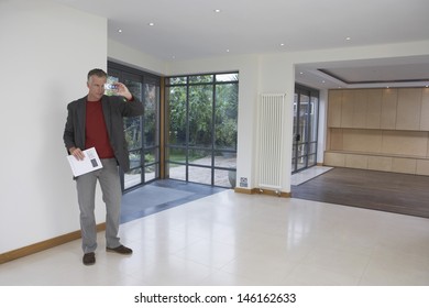 Full Length Of A Male Real Estate Agent Photographing New Property