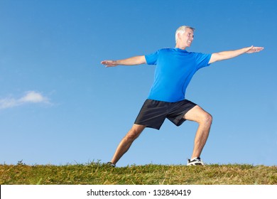 Full length of a mature man in sportswear stretching muscles on ground against sky. Horizontal shot. - Shutterstock ID 132840419