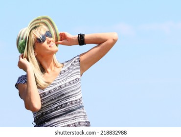 Full Length Mature Woman With Hat On Beach Enjoying Summer Holiday