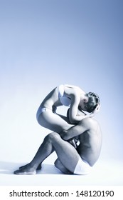 Full Length Of Modern Dance Couple Performing Over Blue Background