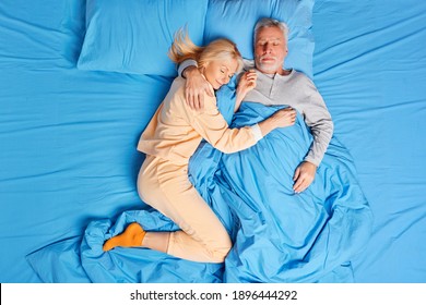 Full length overhead shot of senior couple sleep peacefully together in bed embrace and and have healthy nap rest at home during early morning lying asleep. Bedtime family and relaxation concept - Powered by Shutterstock