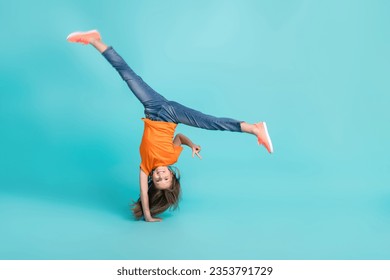 Full length photo of active energetic girl wear trendy clothes playing standing arms v-sign empty space isolated on cyan color background - Powered by Shutterstock