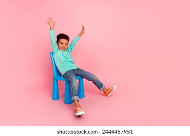 Full length photo of adorable little boy sit chair raise hands cheerful wear trendy aquamarine garment isolated on pink color background - Powered by Shutterstock