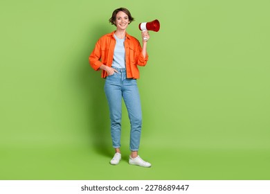 Full length photo of adorable shiny lady dressed jeans shirt holding toa emtpy space isolated green color background