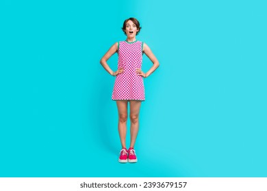 Full length photo of astonished cute girl wear trendy plaid dress impressed good news information isolated on cyan color background