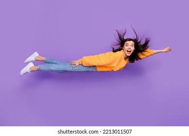 Full length photo of astonished overjoyed cheerful person wear orange trendy sweater denim rush party isolated on purple color background