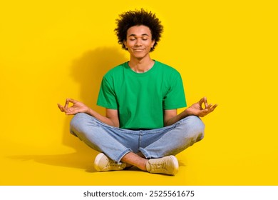 Full length photo of attractive funny guy wear green t-shirt enjoying yoga emtpy space isolated yellow color background - Powered by Shutterstock