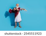 Full length photo of attractive old man stretch hands cast spell magic dressed greek god emperor actor costume isolated on blue background