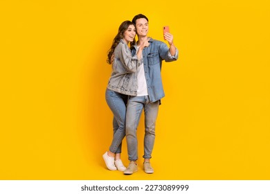 Full length photo of attractive sweet couple wear jeans recording video vlog modern device isolated yellow color background - Powered by Shutterstock