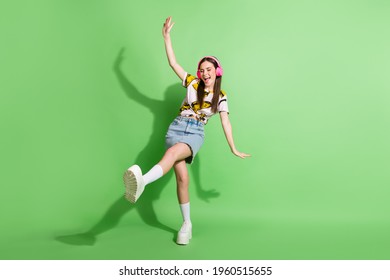 Full length photo of attractive young woman wear headphones dance isolated on green color background - Powered by Shutterstock