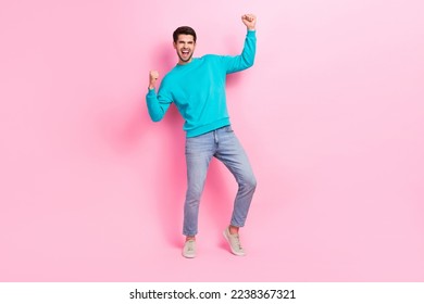 Full length photo of attractive young guy raising fists winner lottery wear trendy blue garment isolated on pink color background - Shutterstock ID 2238367321