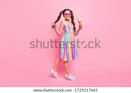 Full length photo of beautiful little lady two cute wavy tails good mood hold big gelato walk street wear colored dress summer sneakers sun specs isolated pastel pink color background