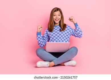Full length photo of blond teenager girl hold laptop yell wear sweater jeans shoes isolated on pink background