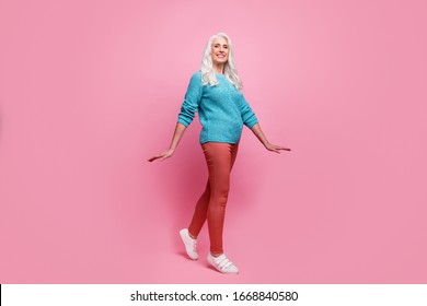 Full Length Photo Of Candid Content Lovely Charming Old Woman Enjoy Free Time Winter Walk Wear Casual Style Pants Gumshoes Isolated Over Pink Color Background