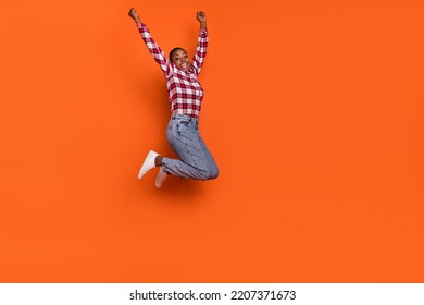 Full length photo of carefree active person jumping raise hands fists isolated on orange color background - Shutterstock ID 2207371673